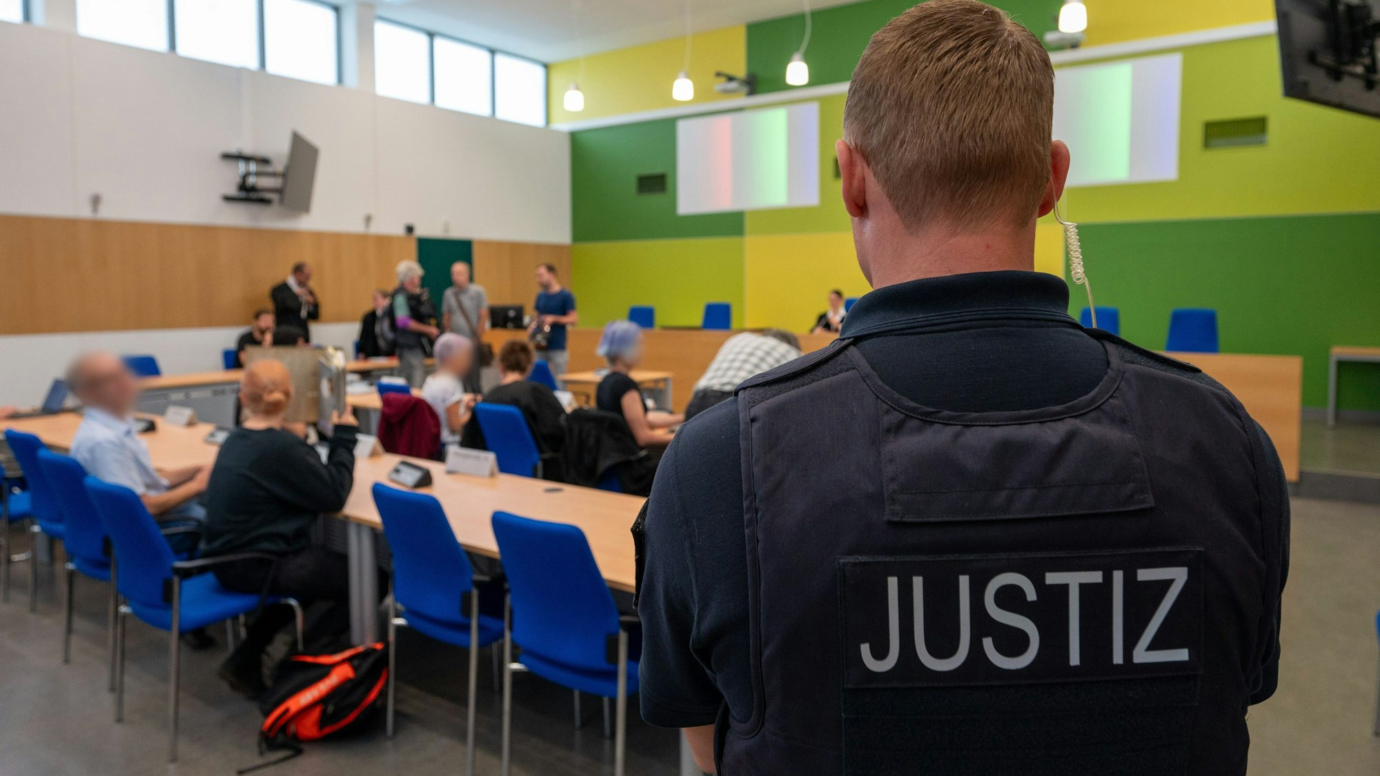 Angeklagte Klimaaktivisten sitzen mit ihren Anwälten in einem Gerichtssaal des Amtsgerichts Trier.