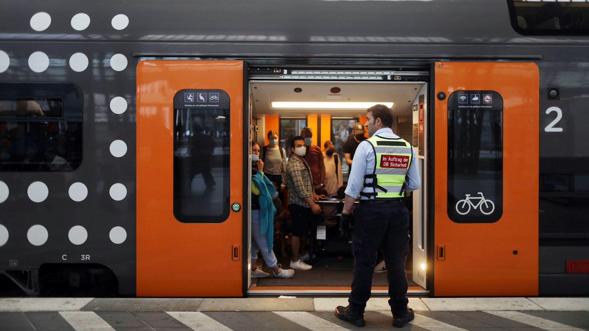 06.06.2022, Köln: Ein Mann von der DB Sicherheit steht vor einem überfüllten Waggon. Ein Zug auf Gleis 6 von Nation Express am Hauptbahnhof. Das 9-Euro-Ticket gilt auch für Natioal Express Verbindungen. Foto: Arton Krasniqi