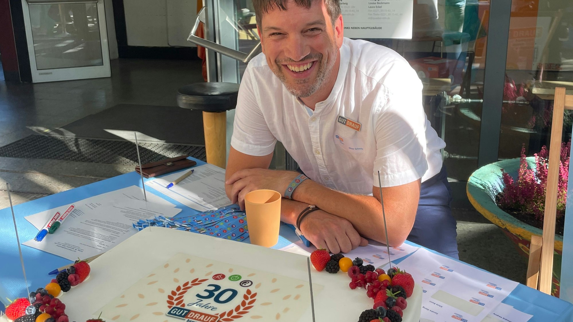 Oliver Schmitz, der Geschäftsführer der Aktion „Gut drauf“ steht hinter der Geburtstagstorte.