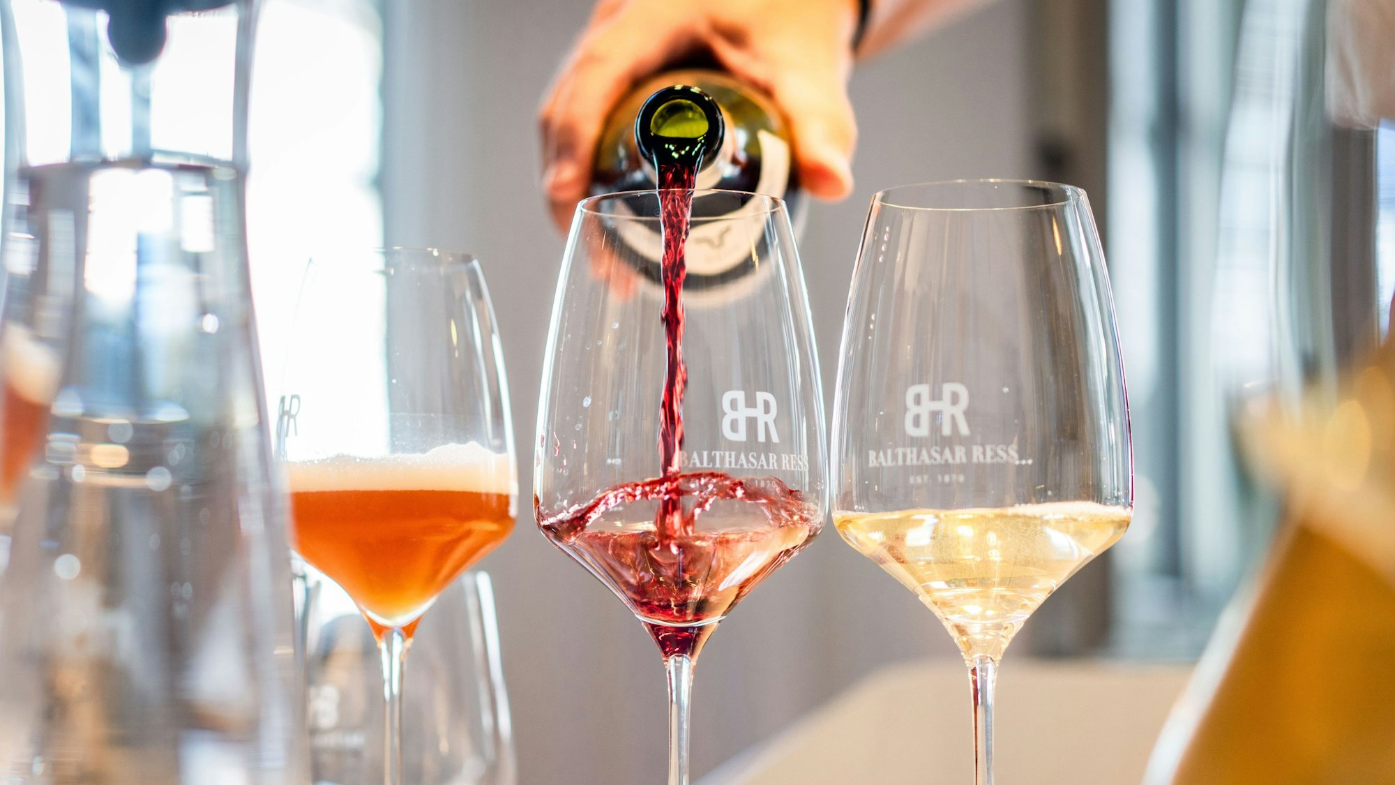 drei Weingläser mit unterschiedlichen Weinen