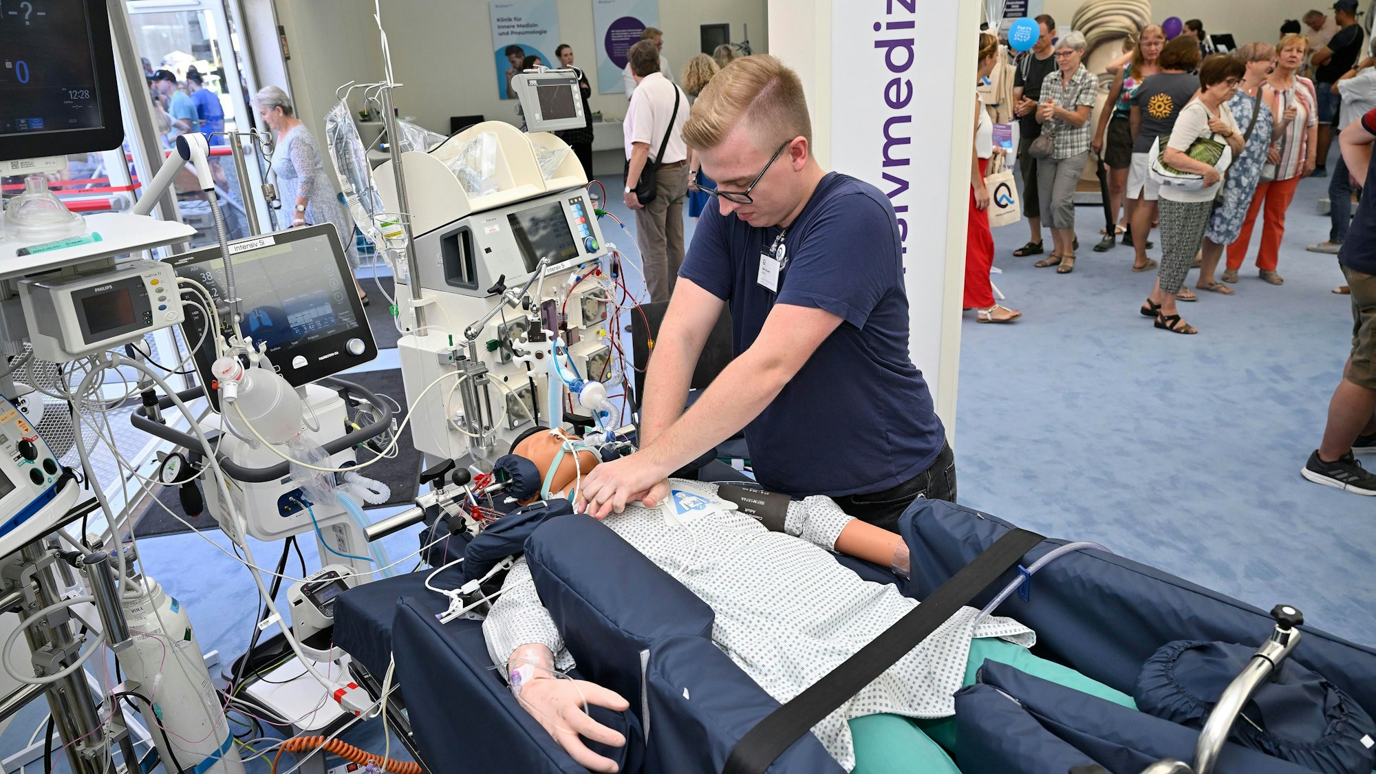 Ein Pfleger demonstriert Hilfstechniken an einem Dummy.