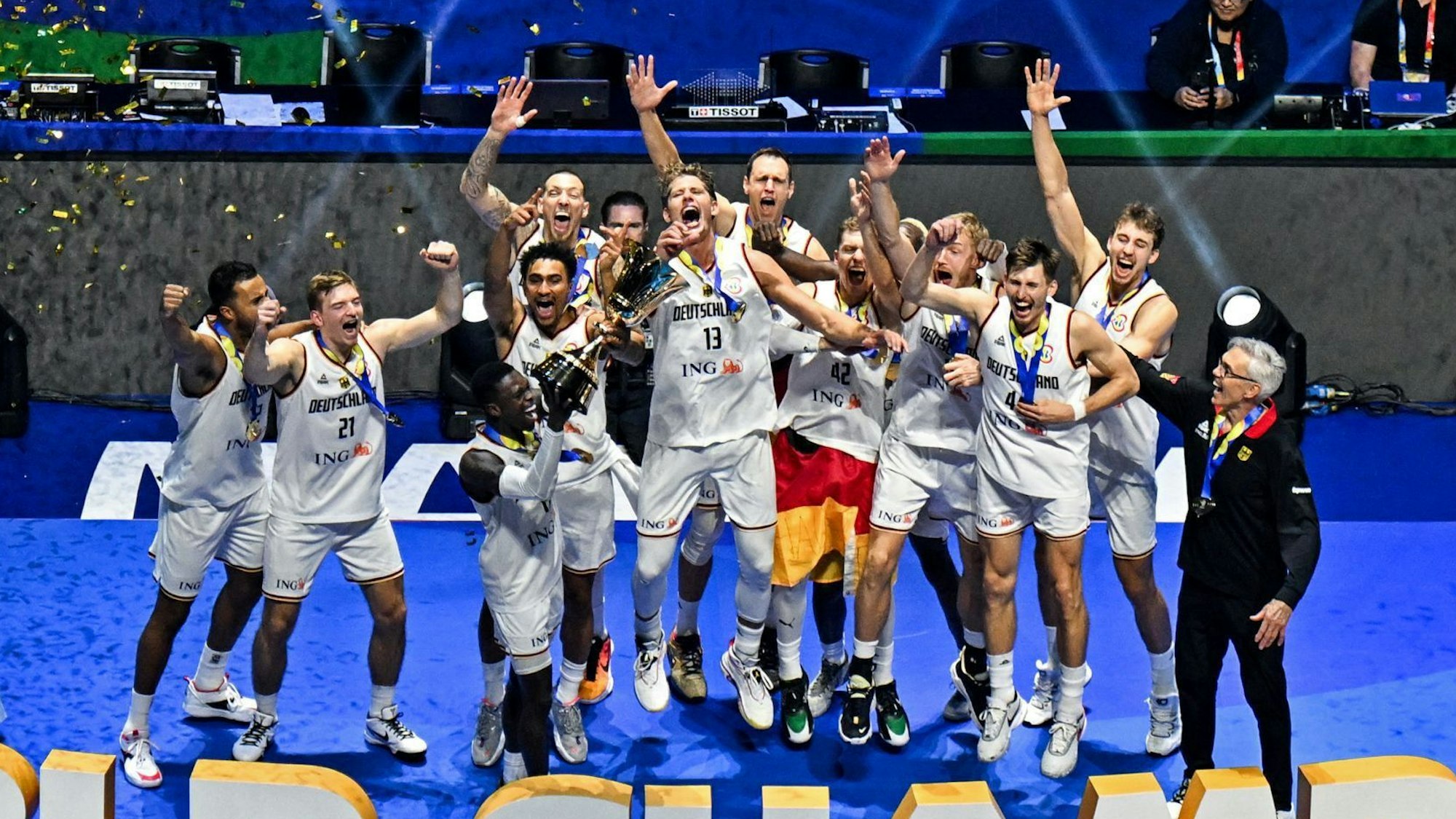 TOPSHOT - Germany's players celebrate with their head coach Gordon Herbert (R) after winning the FIBA Basketball World Cup final game against Serbia in Manila on September 10, 2023. (Photo by SHERWIN VARDELEON / AFP)