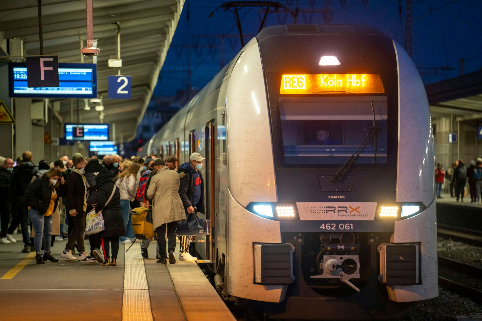 Ein Regionalexpress steht am Kölner Hauptbahnhof, Fahrgäste steigen ein.