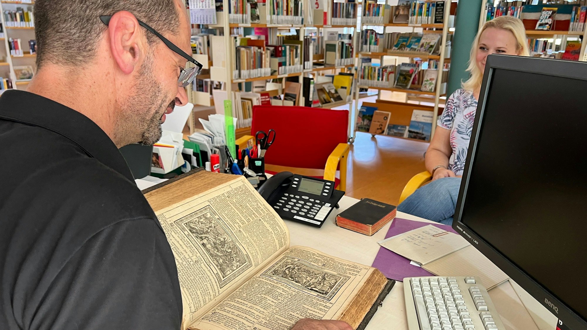 Bibliothekar Marcus Vaillant nimmt eine alte Bibel in Augenschein.