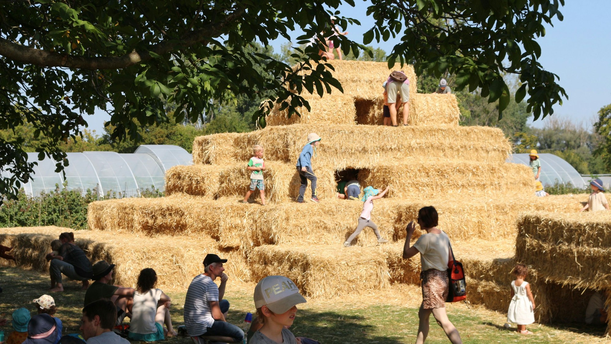 Zahlreiche Kinder klettern auf der aus Strohballen errichteten Burgpyramide.