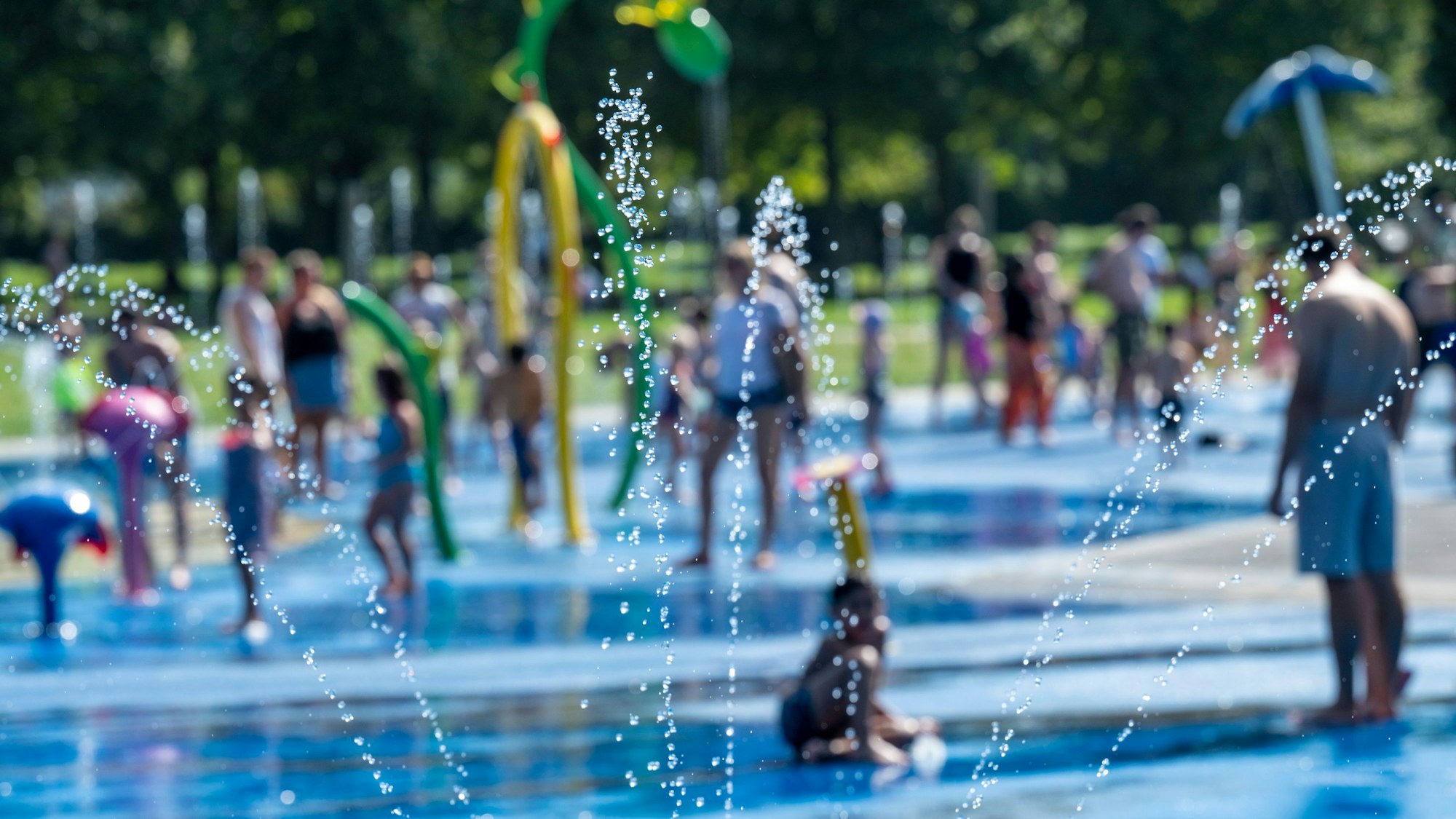 Kinder spielen auf dem Wasserspielplatz im Stadtgarten.