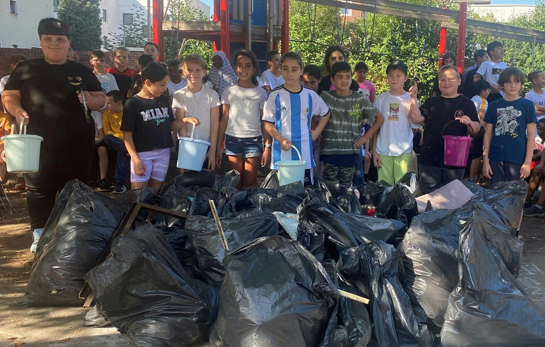 Jungen und Mädchen der Regenbogenschule in Manfort füllten in nur anderthalb Stunden 30 Säcke mit Müll in der Umgebung der Schule.