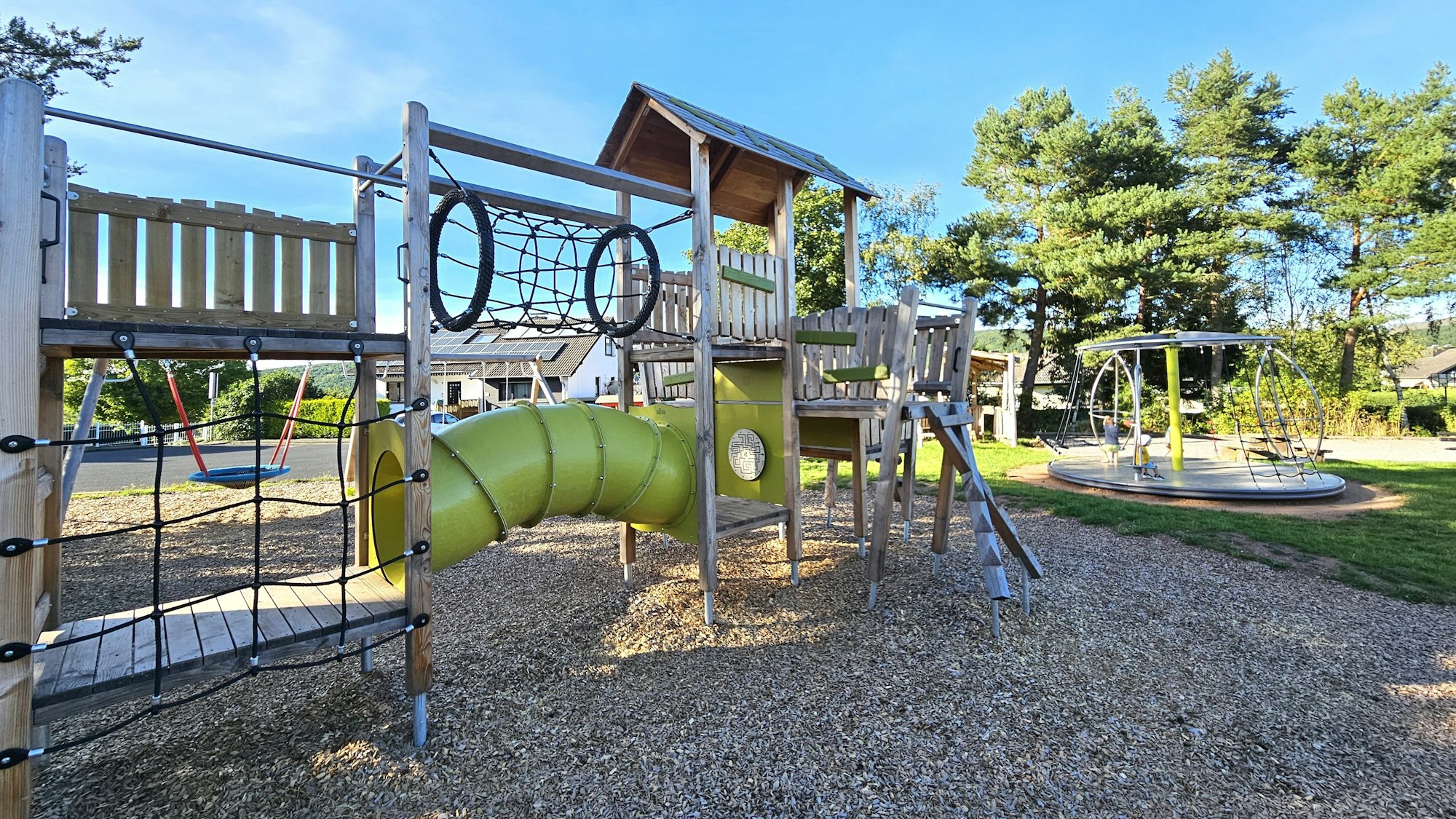 Das Bild zeigt einen modernen Spielplatz mit verschiedenen Kletter- und Spielmöglichkeiten.