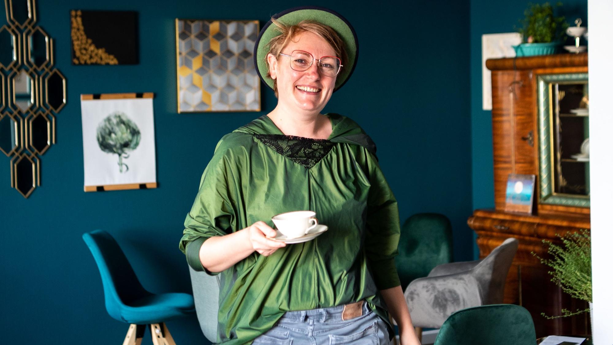 Das Bild zeigt Sandra Wolbert, wie sie eine leere Tasse trägt.
