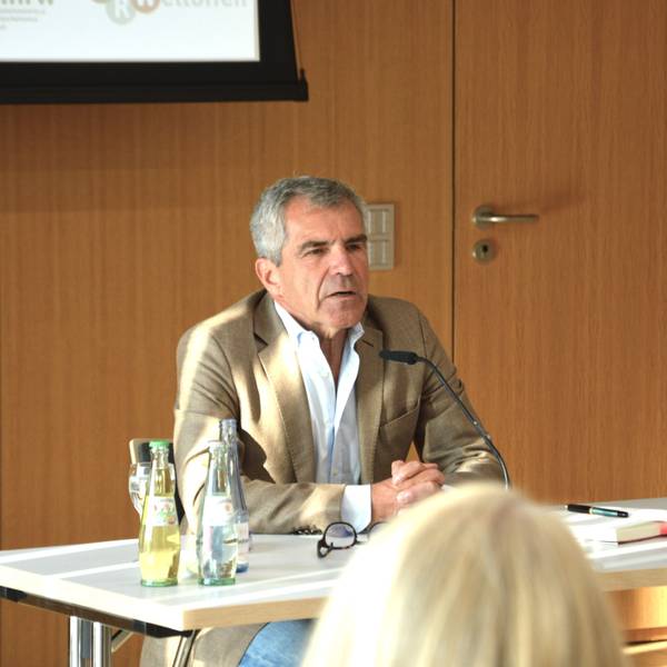 Der Journalist Hans Demmel sitzt an einem Tisch.