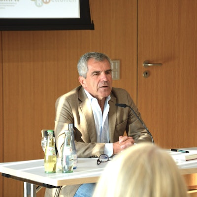 Der Journalist Hans Demmel sitzt an einem Tisch.