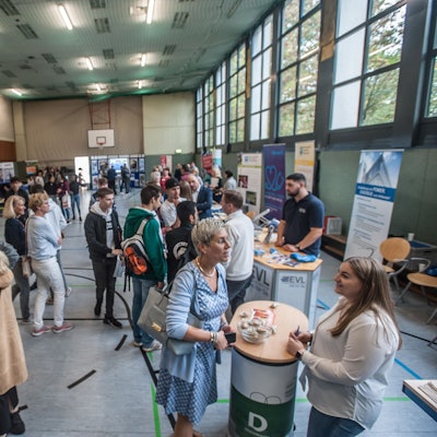 Ausbilder und Azubis stehen am Tag der Bewerbung 2019 in der Sporthalle des Berufskollegs Opladen.