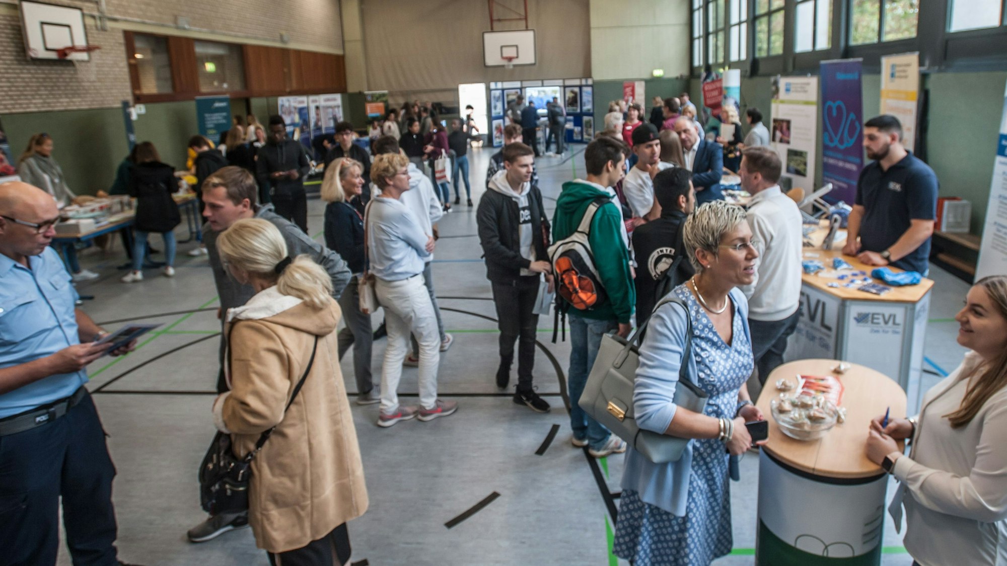 Ausbilder und Azubis stehen am Tag der Bewerbung 2019 in der Sporthalle des Berufskollegs Opladen.