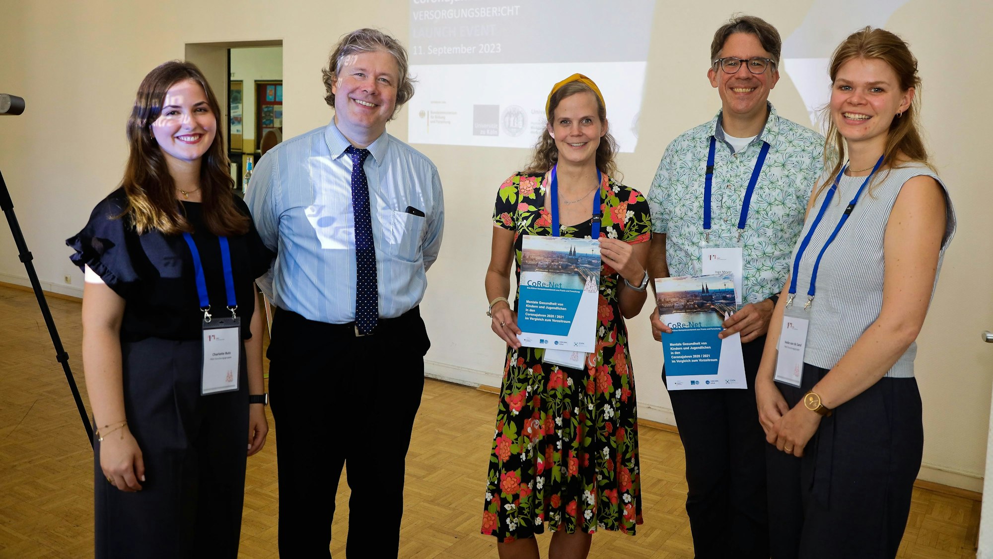 Fünf Personen stehen im Hauptgebäude der Uniklinik und lächeln in die Kamera.