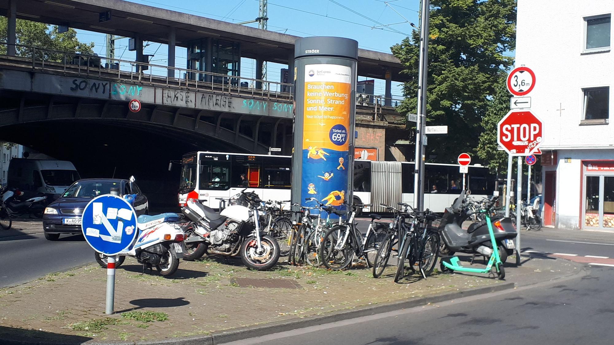 Blick auf den S-Bahnhof, im Vordergrund ist eine Verkehrsinsel mit Litfaßsäule