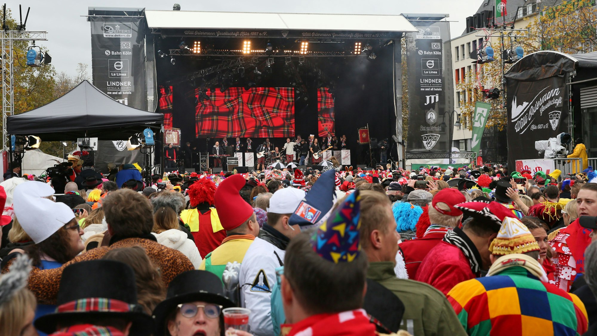 Eine Menschenmenge steht verkleidet vor einer Bühne.