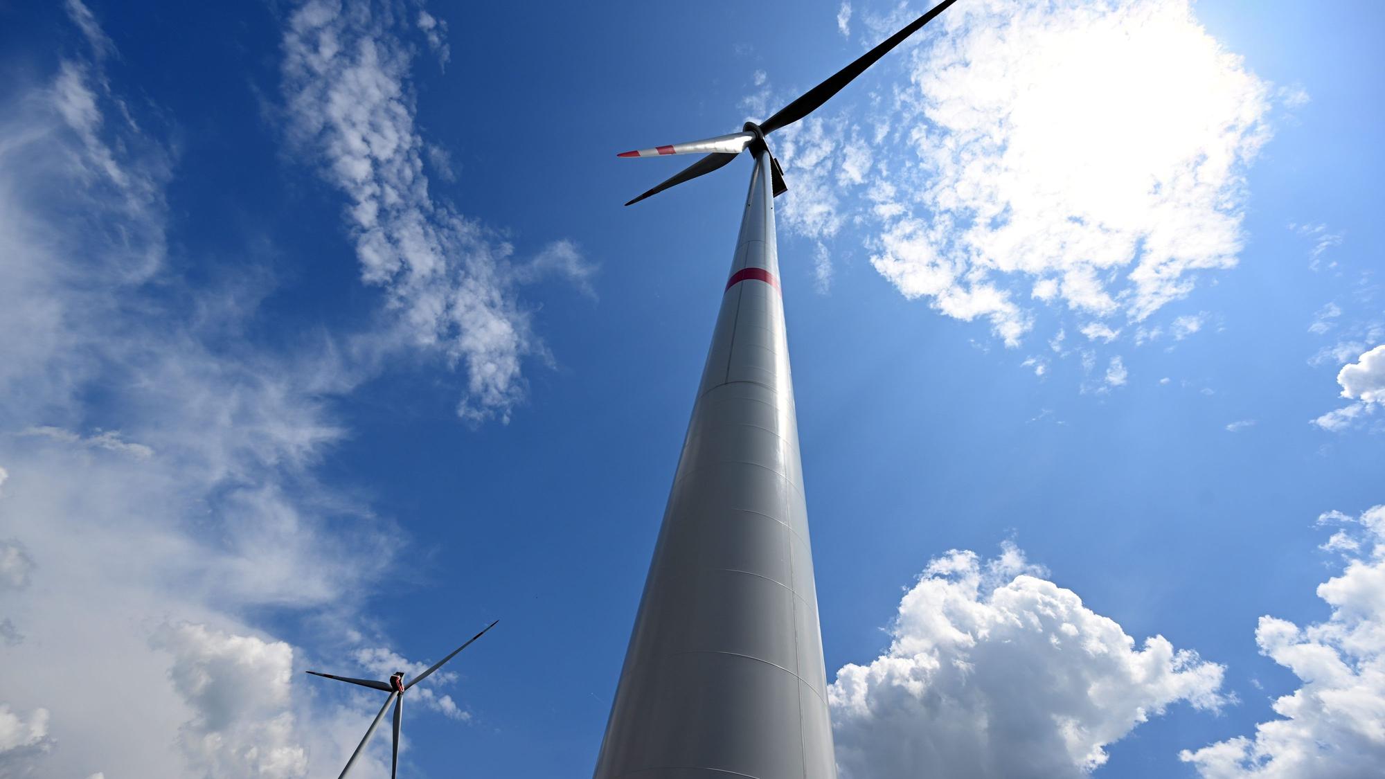Wolken ziehen über Windräder zur Stromerzeugung.