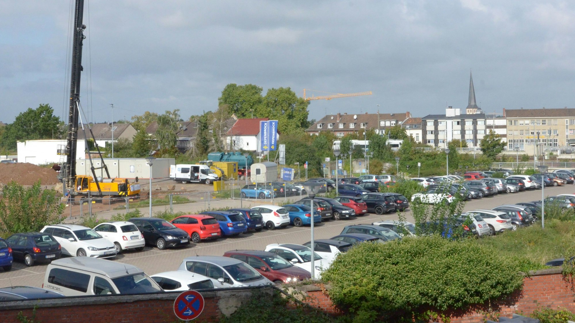 Hinter einem komplett mit Autos belegten Parkplatz liegt das Gelände, auf dem die Stadt Euskirchen ihr Rathaus baut.