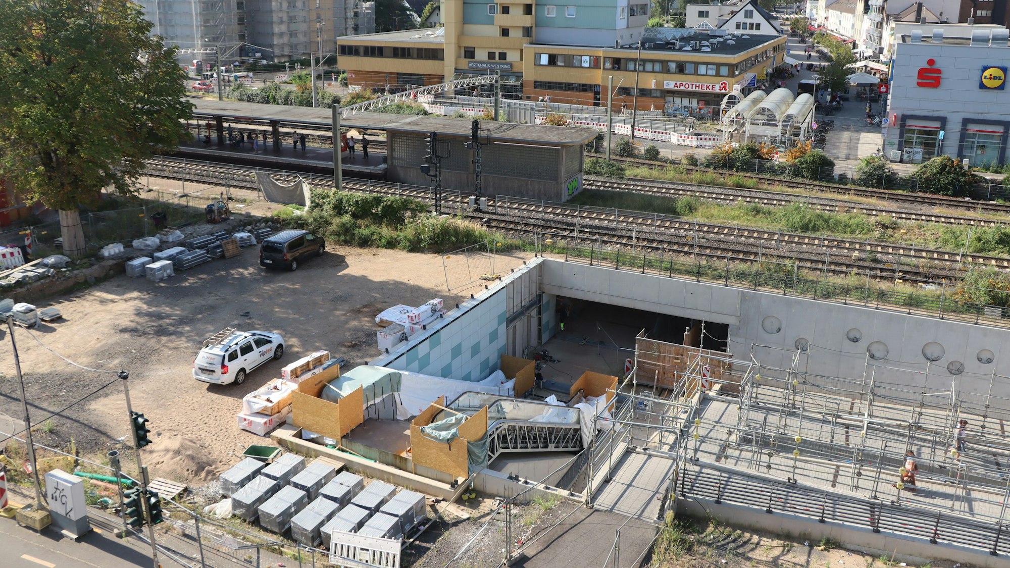 Aus der Luft ist gut zu erkennen, dass der Bahnhof noch eine große Baustelle ist. Neben den Rampen lagern die Bodenplatten, die eigentlich hätten längst verlegt werden sollen.