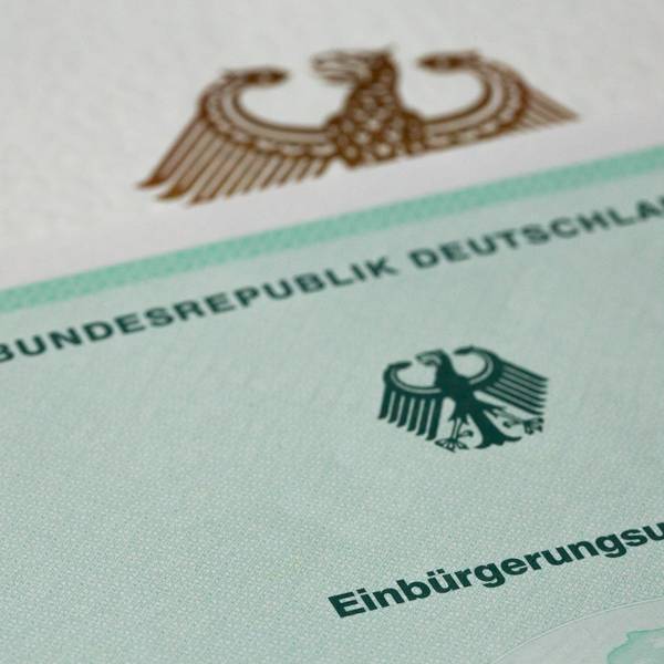 Eine Einbürgerungsurkunde der Bundesrepublik Deutschland liegt auf einem Tisch.