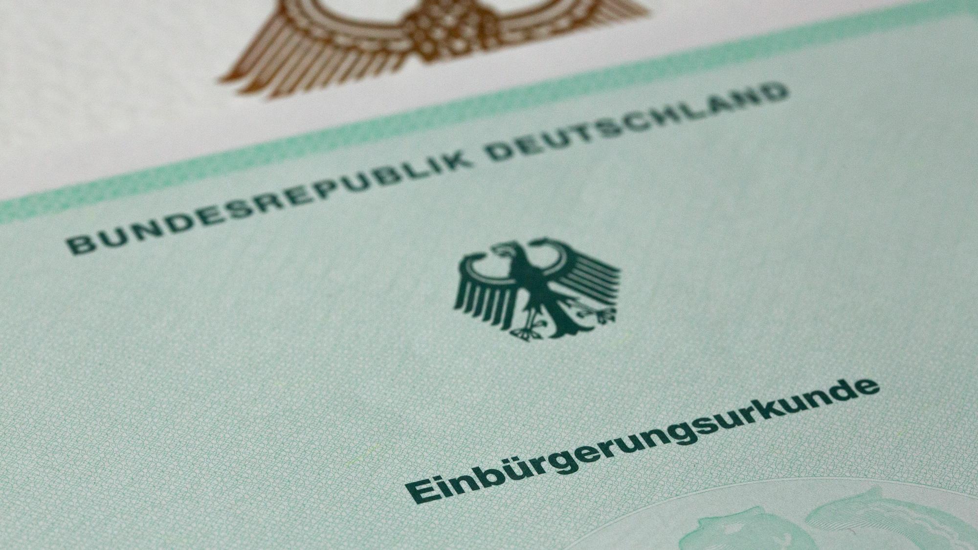 Eine Einbürgerungsurkunde der Bundesrepublik Deutschland liegt auf einem Tisch.