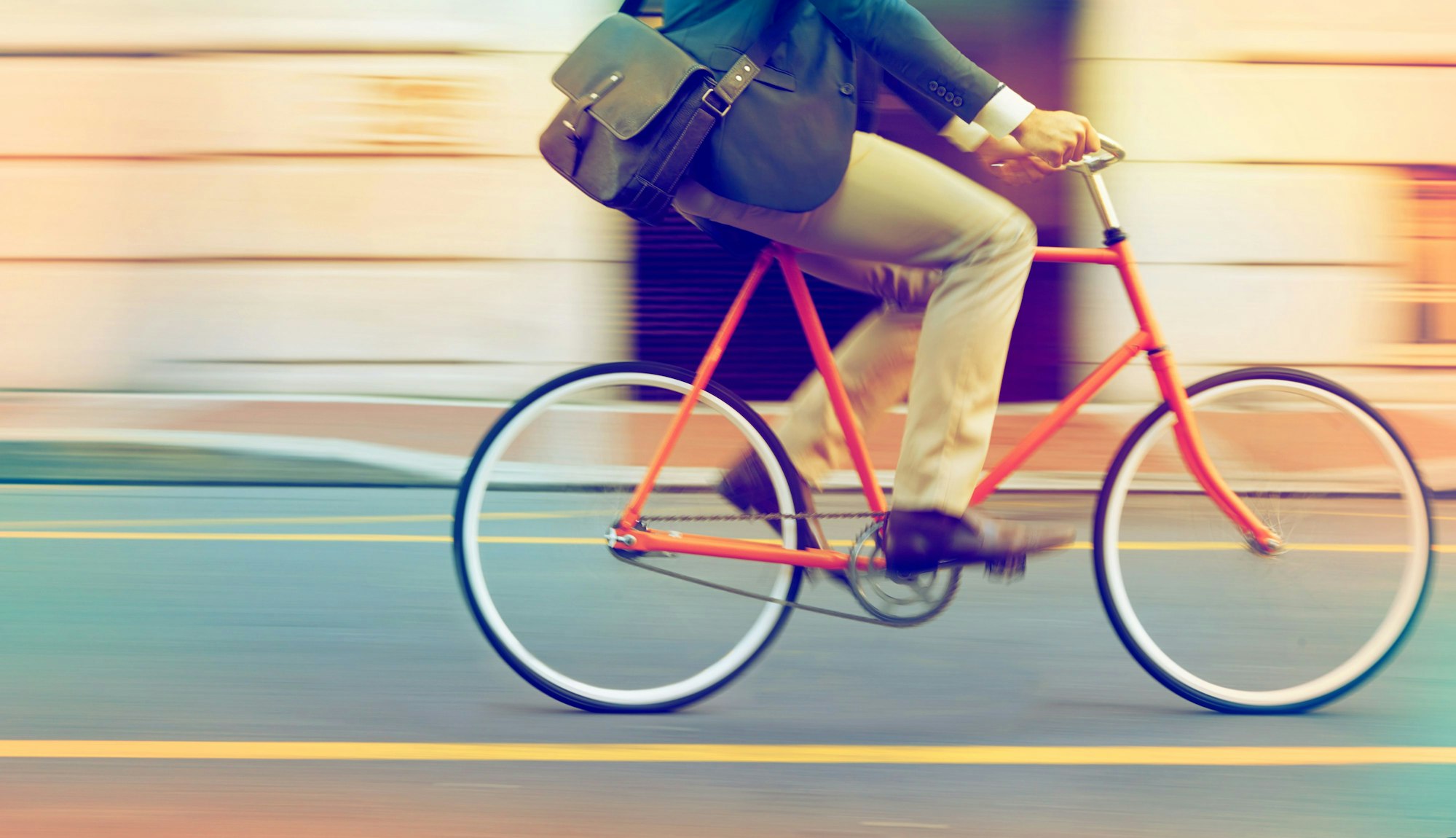 Mann fährt mit Arbeitstasche auf einem Fahrrad Foto: Getty Images/iStockphoto