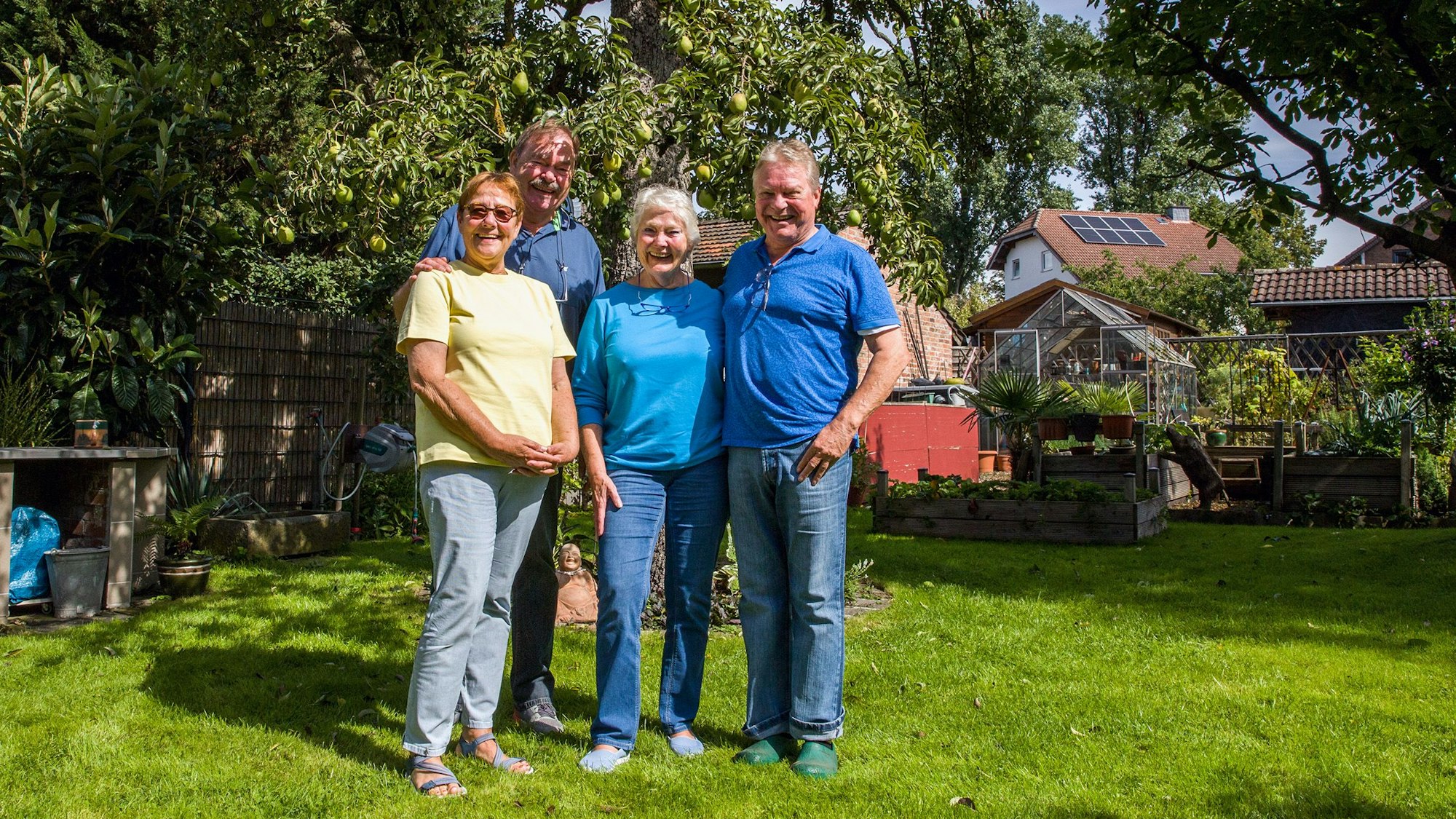 Gabi und Günni Kühn und Gabie und Günter Schweitz stehen vor ihrem Birnbaum im Garten.