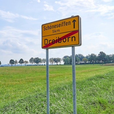 Das Bild zeigt das Schild am Ortsausgang von Dreiborn mit dem Hinweis, dass es fünf Kilometer bis zum Nachbarort Schöneseiffen sind.
