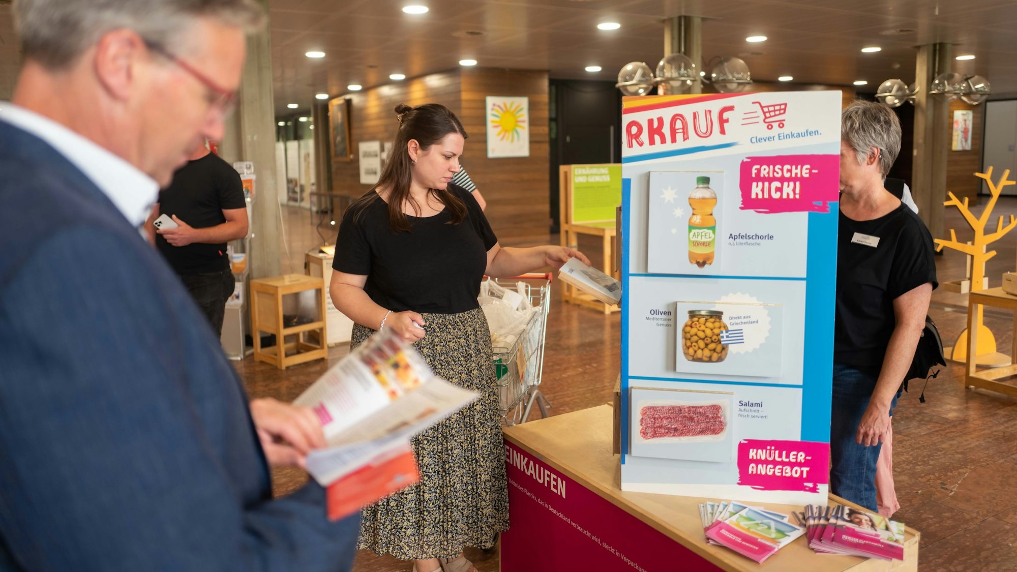 Das Bild gibt einen Blick in die Ausstellung. Unter anderem liest ein Mann in einem Flyer.