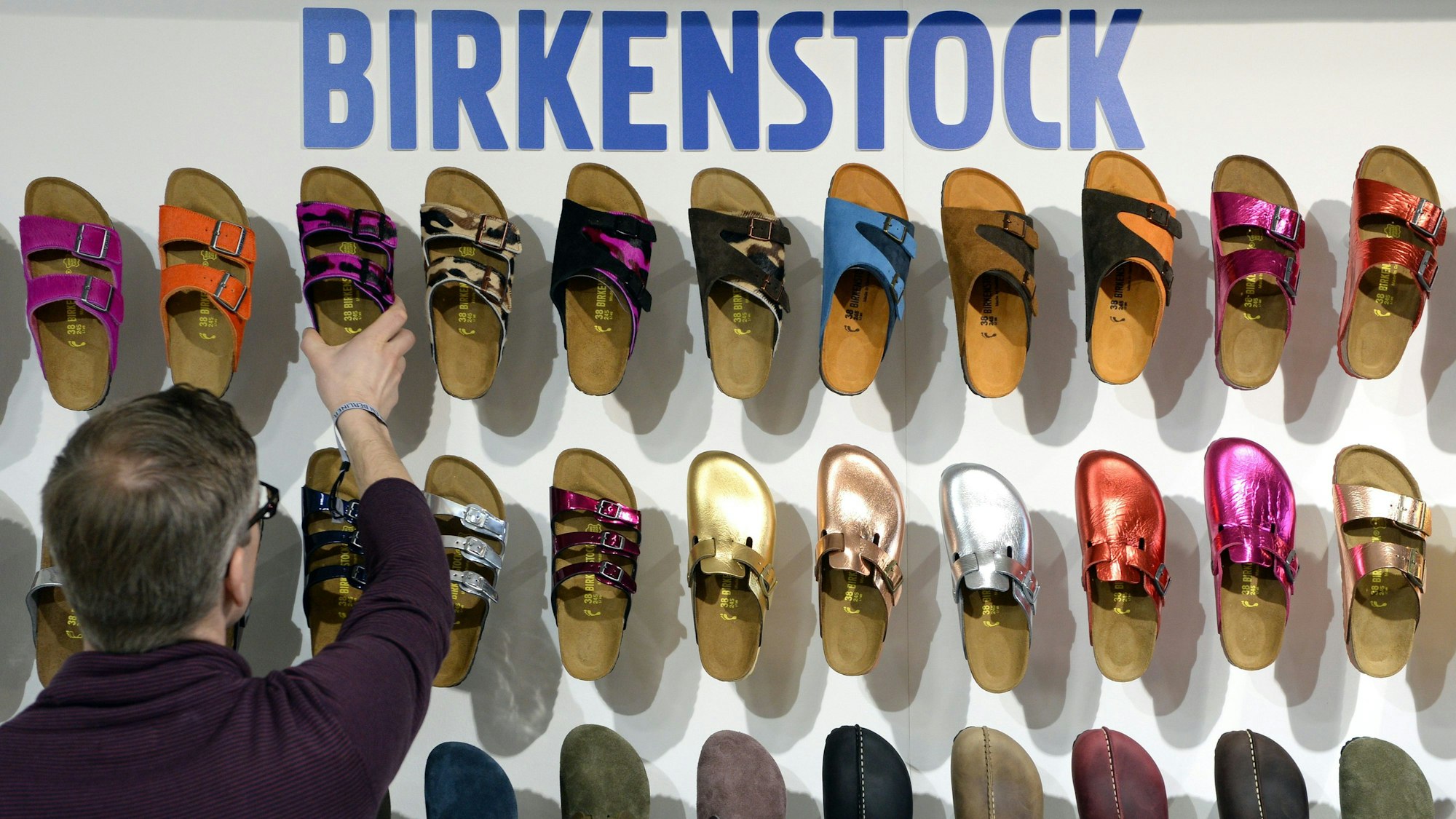 Ein Mitarbeiter sortiert auf der Modemesse "Bread & Butter" auf dem Gelände des früheren Flughafens Tempelhof in Berlin Schuhe des Herstellers Birkenstock. Der traditionsreiche Sandalen-Hersteller Birkenstock geht in den USA an die Börse.