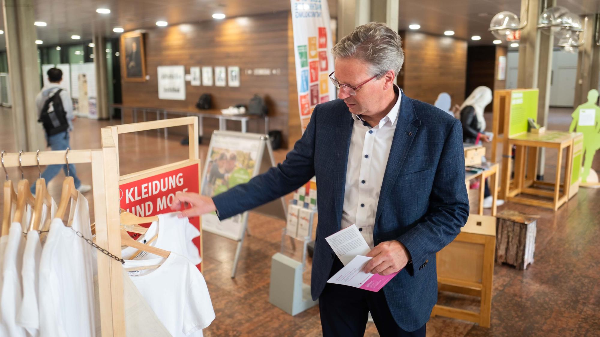 Das Bild zeigt Achim Blindert, wie er sich ein T-Shirt anschaut.