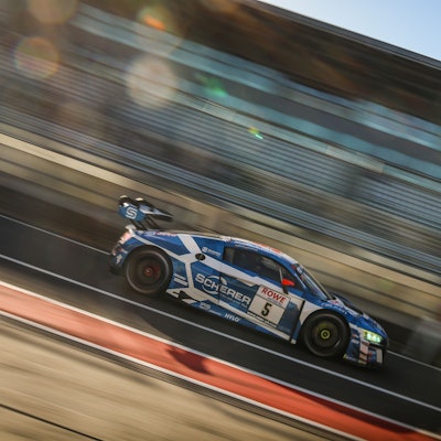 Der Audi von Frank Stippler rast über die Strecke, der Hintergrund ist verwischt.