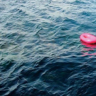 Vier rosa Boote schaukeln auf den Wellen.