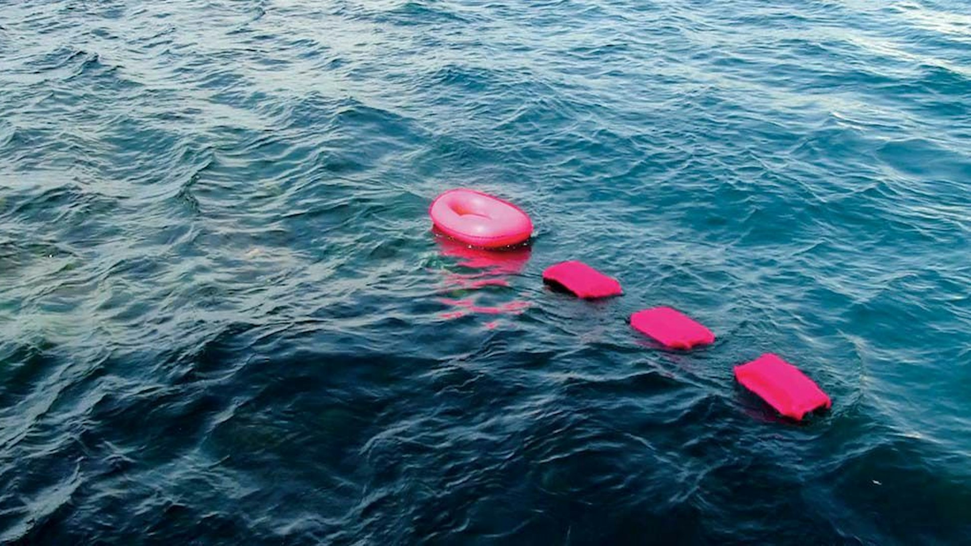 Vier rosa Boote schaukeln auf den Wellen.