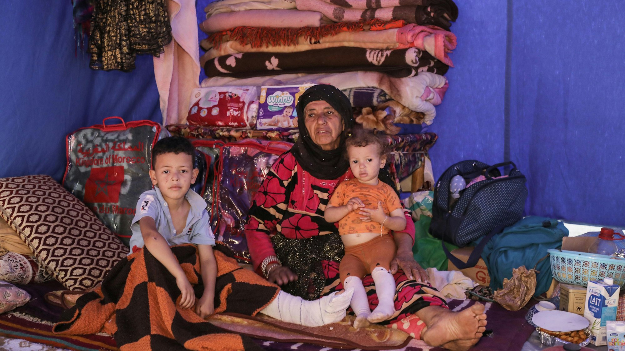 Marokko, Al Haouz: Die 67-jährige Fatima sitzt mit ihrer Familie in einem Zelt eines provisorischen marokkanischen Zivilschutzlagers, das für die Opfer des schweren Erdbebens eingerichtet wurde. Nach dem Erdbeben am 8. September 2023 mangelt es Betroffenen an Lebensmitteln und Wasser.