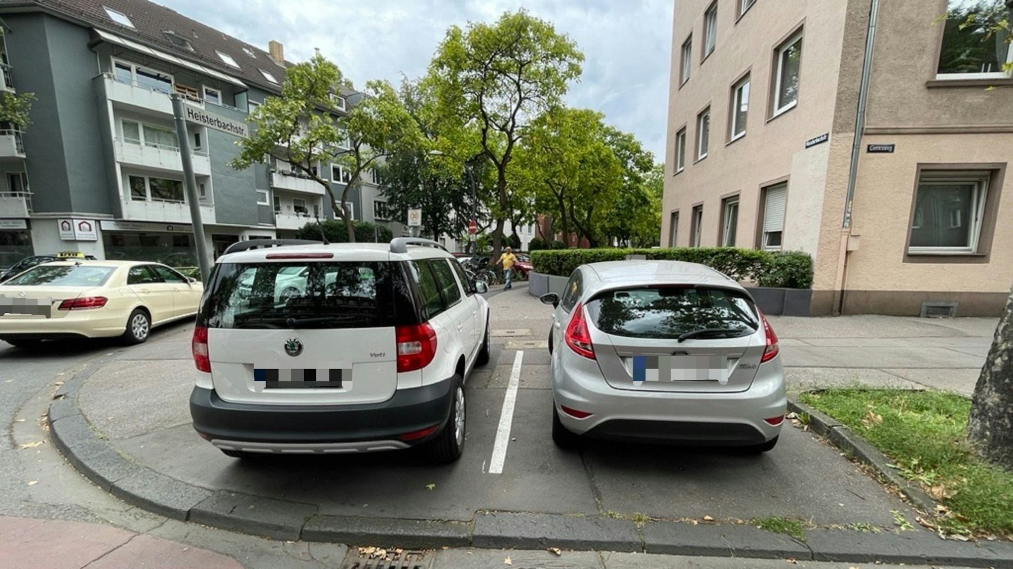 Zwei Autos stehen nebeneinander auf einem Gehweg.