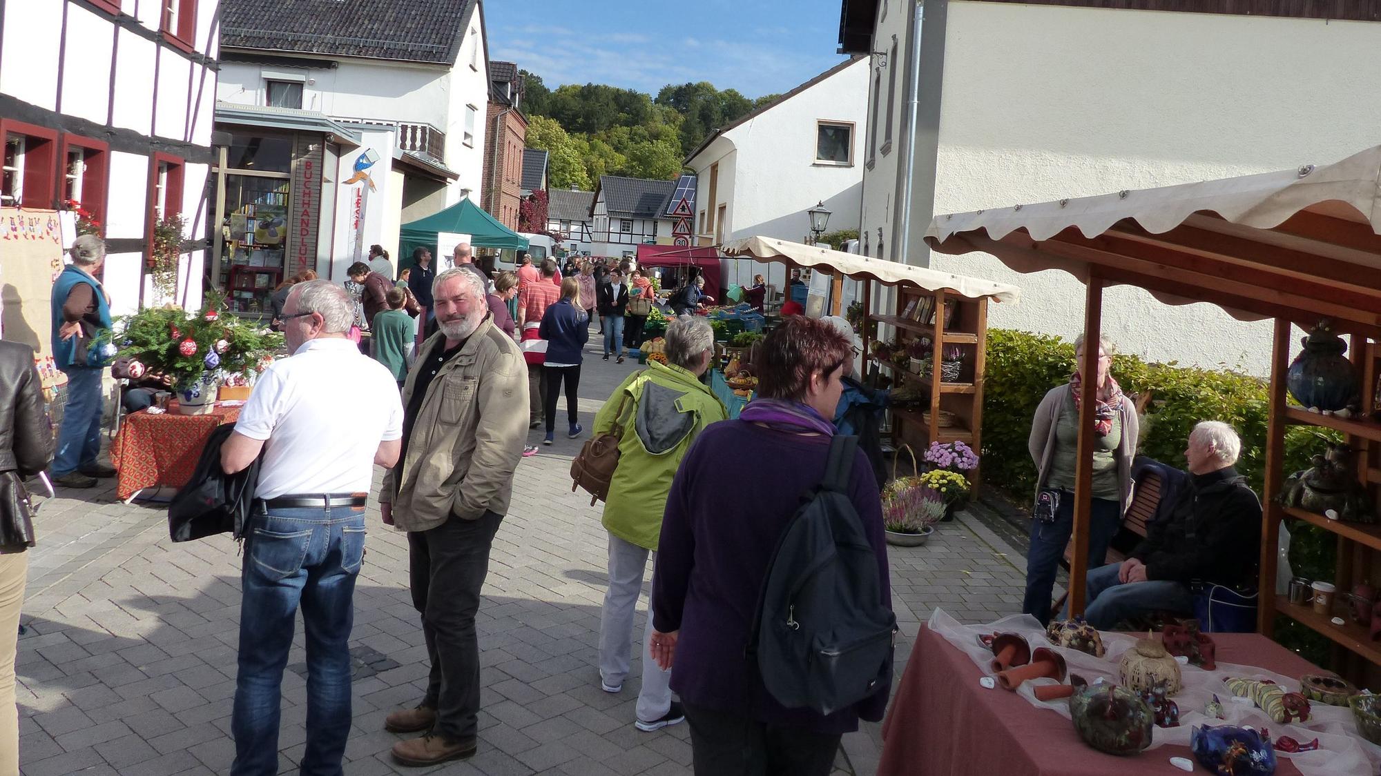 Menschen gehen entlang verschiedener Marktstände.