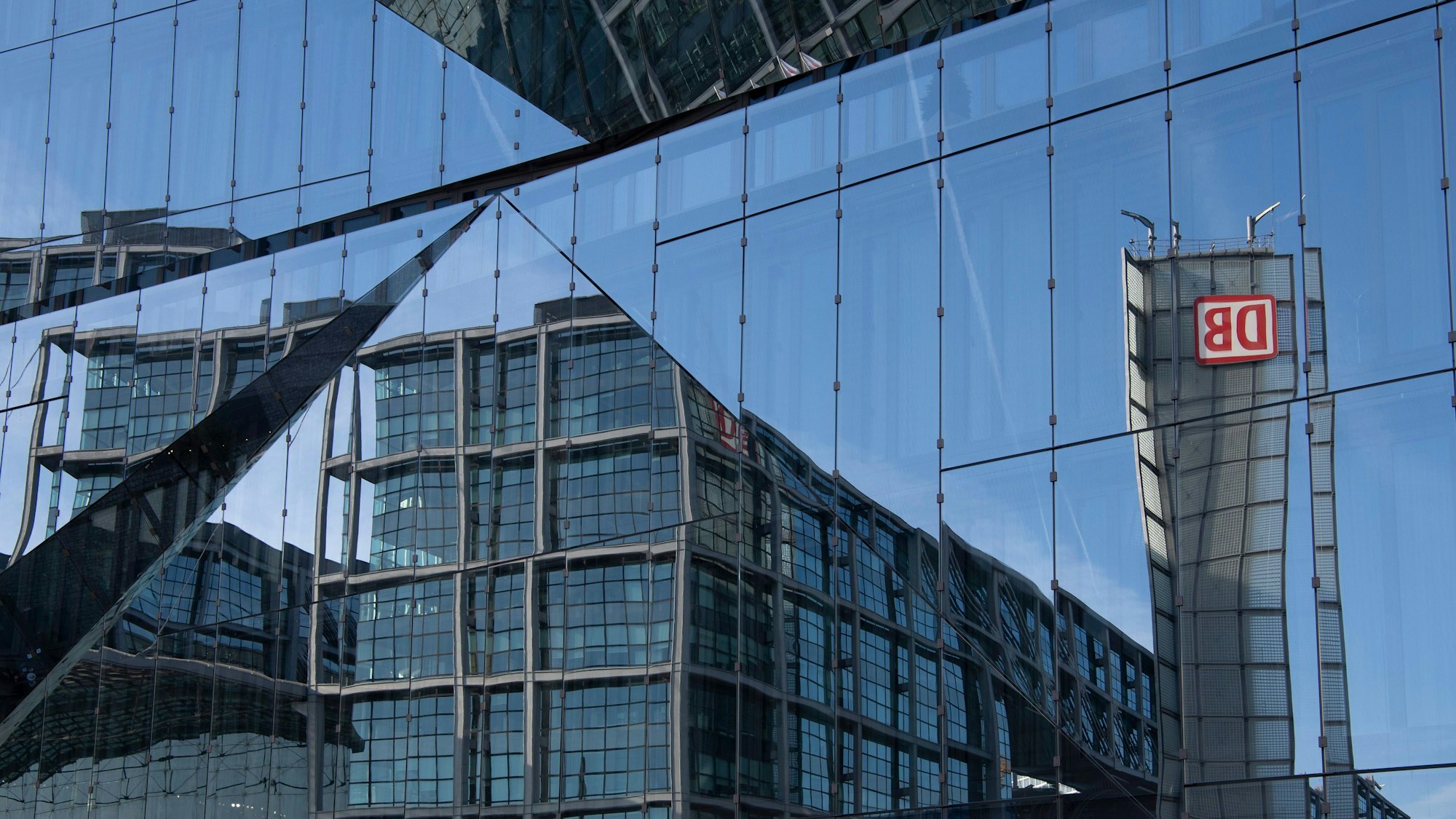 Teile des Berliner Hauptbahnhofes spiegeln sich in einer Fassade.