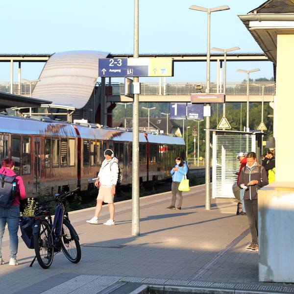 Ein Zug steht im Overather Bahnhof, Fahrgäste stehen auf dem Bahnsteig.