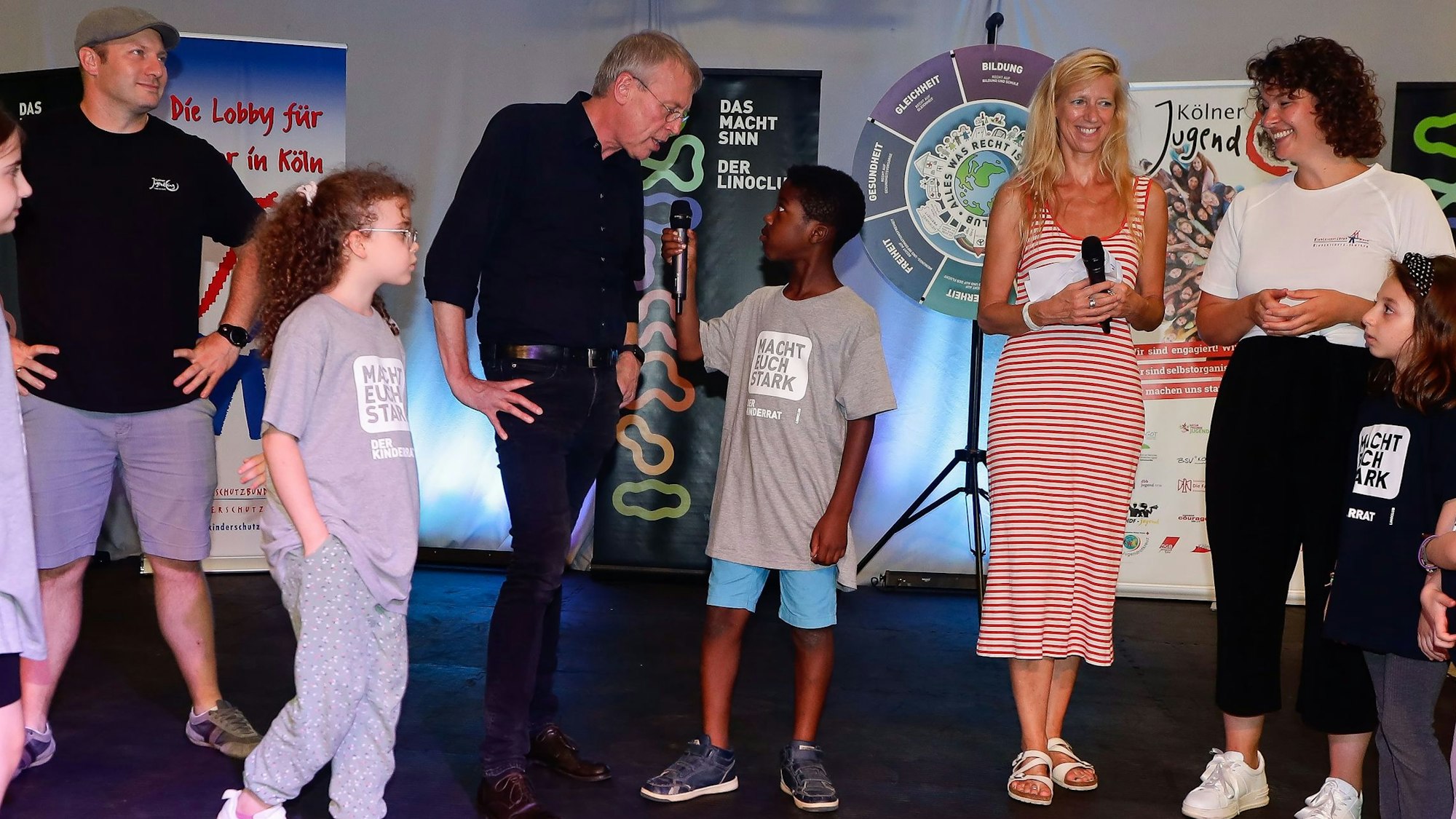 Mitglieder des „Linoclub“-Kinderrats interviewen Thorsten Buff (Geschäftsführer Kölner Jugendring), Hans-Josef Saxler (Geschäftsführer „Linoclub“), Moderatorin Insa Backe und Jessica Schütz (Öffentlichkeitsarbeit Kinderschutzbund Köln) bei der Generalprobe des Weltkindertag-Bühnenprogramms.