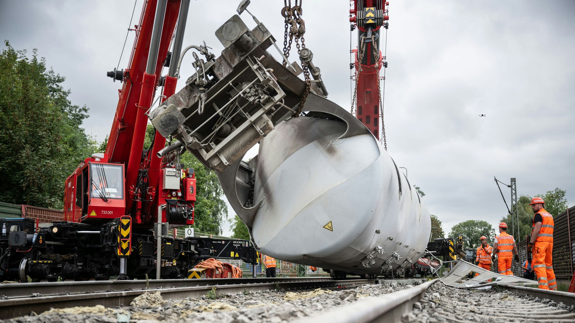 Arbeiter versuchen mit einem Kran den entgleisten Güterzug im nordrhein-westfälischen Geseke von den Gleisen zu bergen. Die Bahnstrecke zwischen Paderborn und Lippstadt bleibt für Wochen gesperrt.