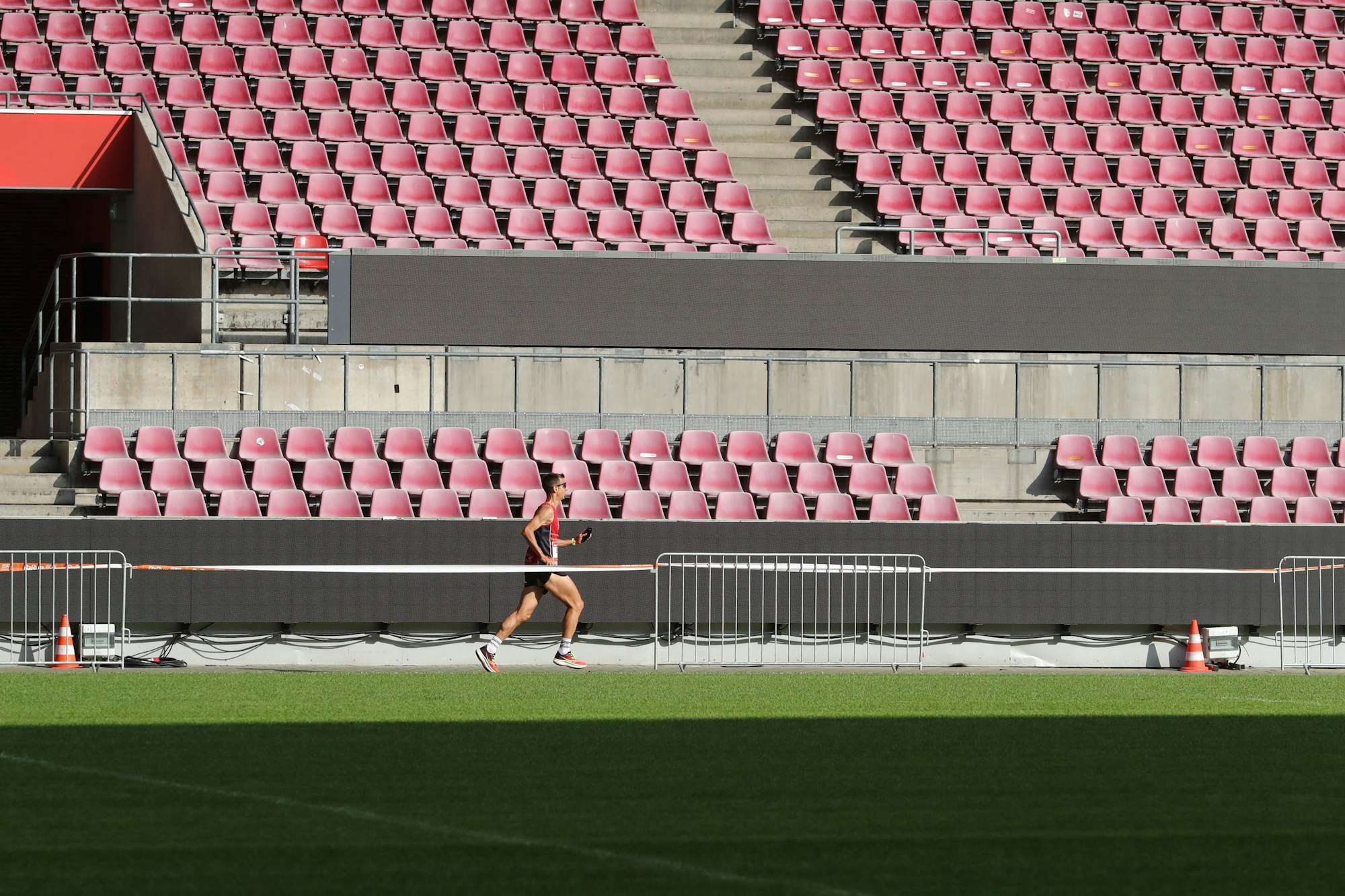 Ein Läufer vor den Rängen des Stadions auf dem Weg ins Ziel
