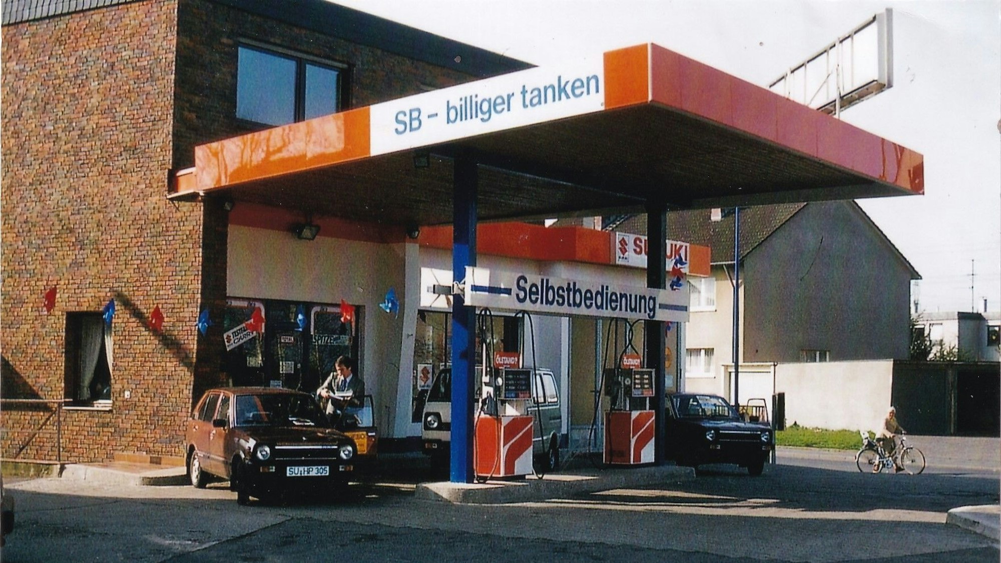 Eine Tankstelle in den 1980er Jahren. „Selbstbedienung“ steht über der Eingangstür, „SB-billiger tanken“ am Dach.