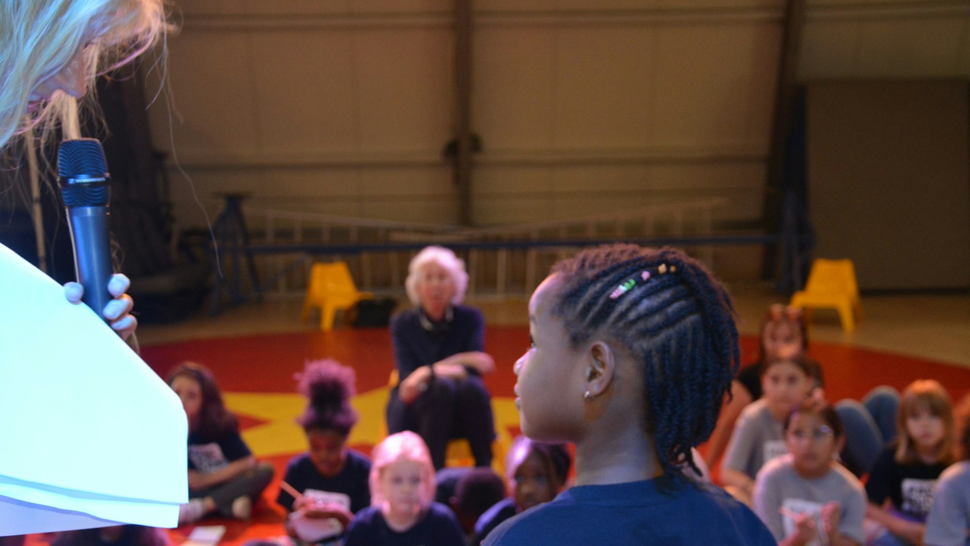 Die WDR-Moderatorin Insa Backe interviewt ein Mädchen vom Linoclub-Kinderrat, im Hintergrund sitzt Hedwig Neven DuMont in der Manege umringt von Kindern.