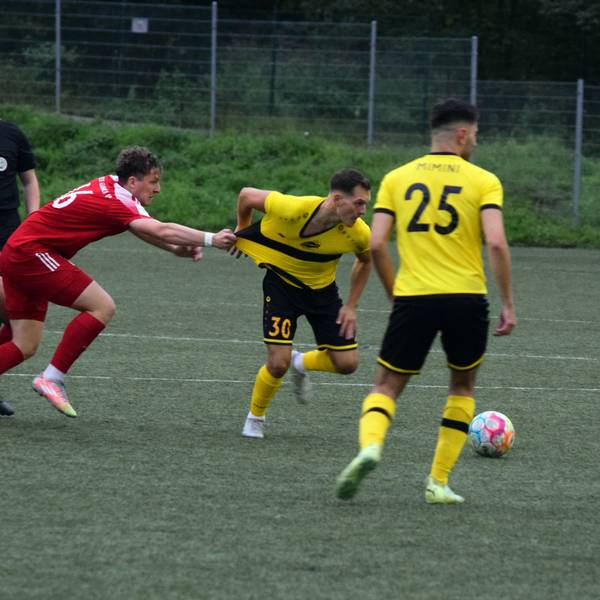 Bergisch Gladbachs Fußballer Nico Kuhbier zieht am Trikot des Hohkeppelers Ansgar Pflüger, um diesen vom Ball fernzuhalten.