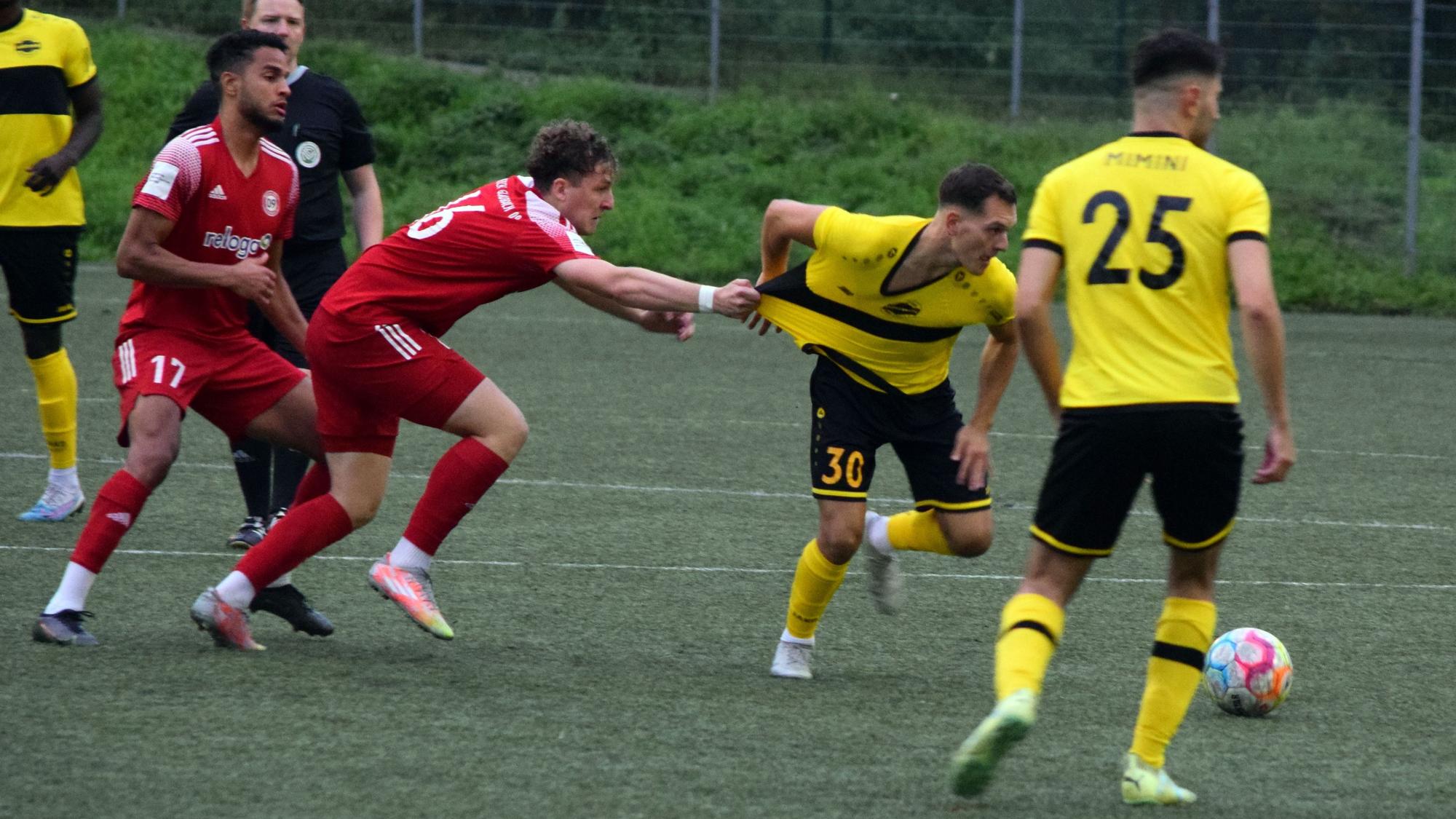 Bergisch Gladbachs Fußballer Nico Kuhbier zieht am Trikot des Hohkeppelers Ansgar Pflüger, um diesen vom Ball fernzuhalten.