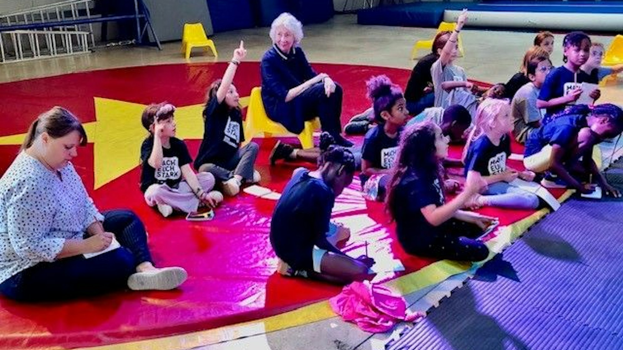 Hedwig Neven DuMont sitzt mit den jungen Mitgliedern des Kinderrats in der Manage der „Linoclub“-Zirkushalle in Köln-Lindweiler.