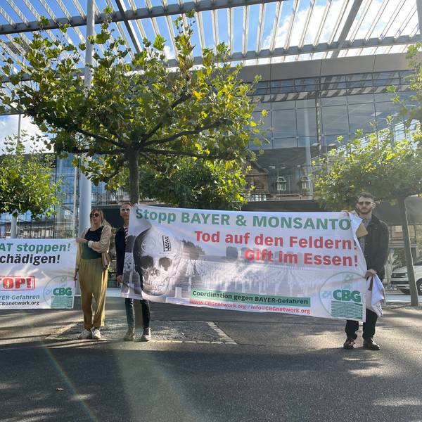 Aktivisten der „Coordination gegen Bayer-Gefahren“ stehen mit Transparenten vor der Konzernzentrale