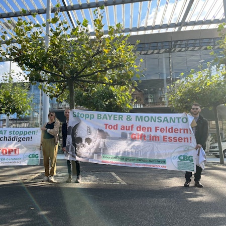 Aktivisten der „Coordination gegen Bayer-Gefahren“ stehen mit Transparenten vor der Konzernzentrale