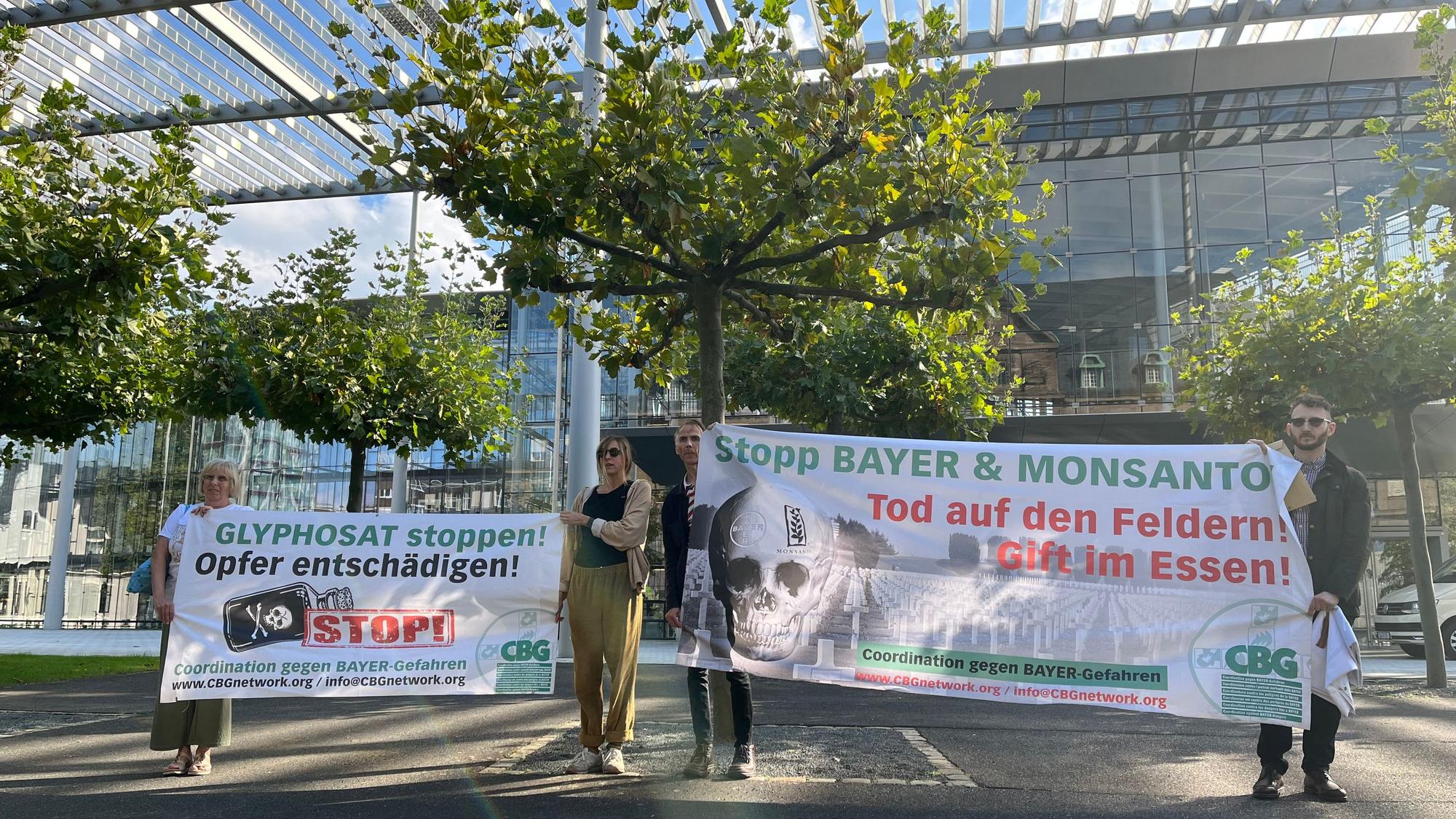 Aktivisten der „Coordination gegen Bayer-Gefahren“ stehen mit Transparenten vor der Konzernzentrale